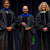Faculty member posing with the Provost and Robert Smart